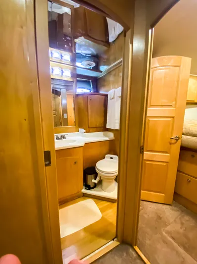 Boom Yacht Photos Pics Compact bathroom in a 1999 Navigator 5800 yacht with wooden cabinetry and modern fixtures.