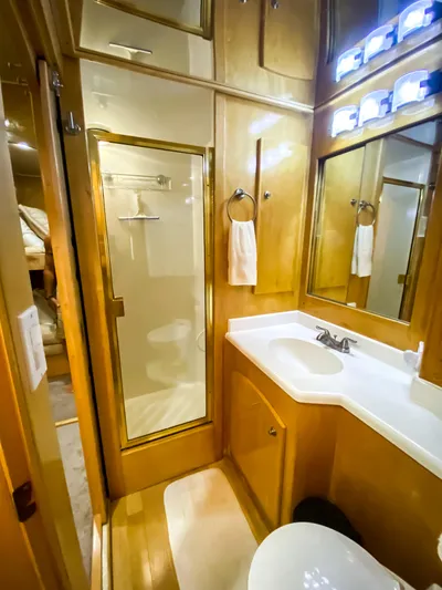 Boom Yacht Photos Pics Luxurious bathroom in 1999 Navigator 5800 yacht with wood cabinetry and modern fixtures.