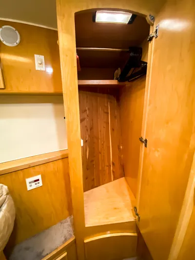 Boom Yacht Photos Pics Wooden closet interior in 1999 Navigator 5800 model, featuring shelves and hangers.