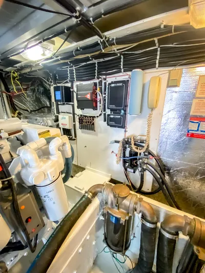 Boom Yacht Photos Pics Engine room of 1999 Navigator 5800 yacht with control panels and piping.