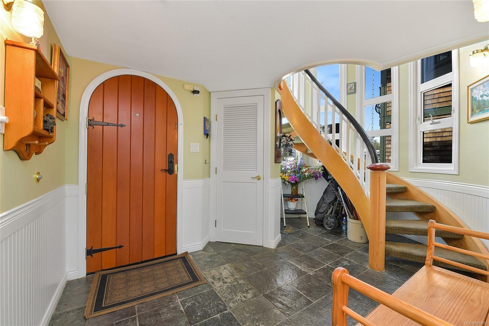 Entrance of a custom 2005 float home with curved staircase and wooden door.