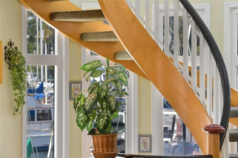  Yacht Photos Pics Curved wooden staircase in a 2005 custom float home with potted plants and marina view.