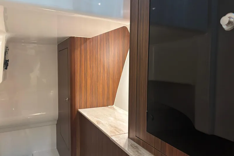  Yacht Photos Pics 2020 Pursuit DC 365 Dual Console interior with wood finish and storage cabinet.