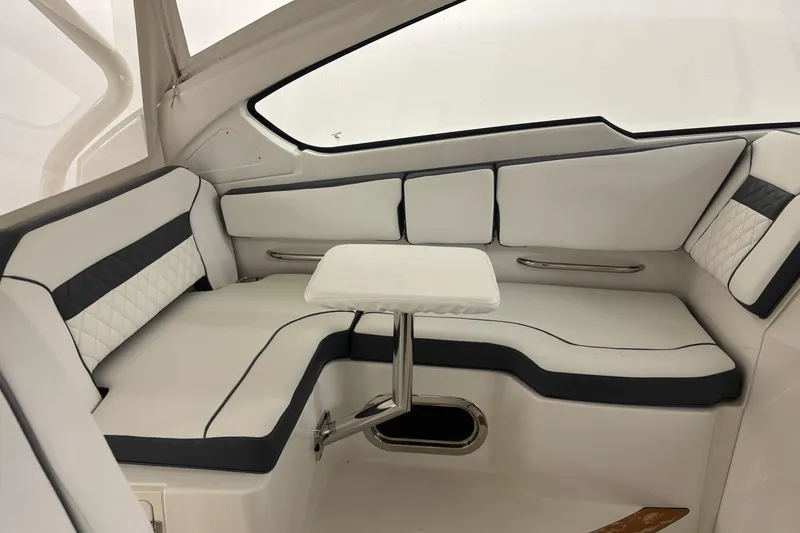  Yacht Photos Pics 2020 Pursuit DC 365 Dual Console interior with white seating and small table.