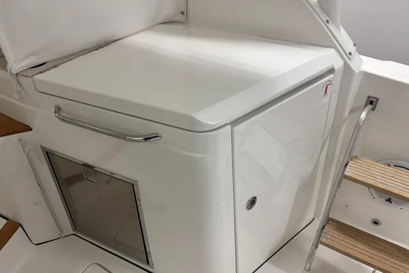  Yacht Photos Pics 2020 Pursuit DC 365 Dual Console boat interior with storage compartment and wooden steps.