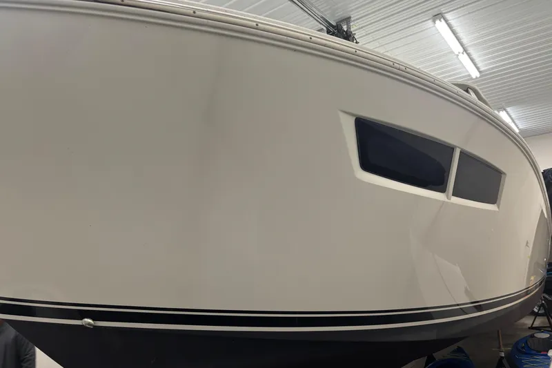  Yacht Photos Pics 2020 Pursuit DC 365 Dual Console boat in indoor storage, side view.
