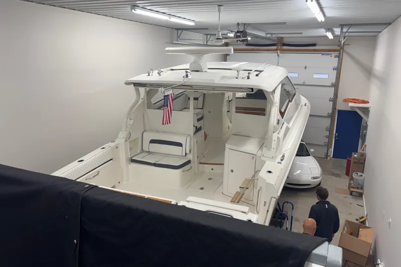  Yacht Photos Pics 2020 Pursuit DC 365 Dual Console boat in a garage with an American flag.