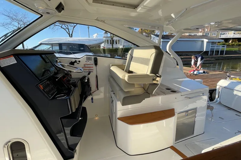  Yacht Photos Pics 2020 Pursuit DC 365 Dual Console interior with helm and seating, dockside view.