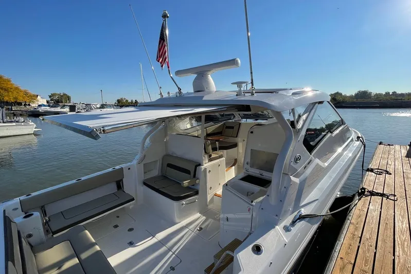  Yacht Photos Pics 2020 Pursuit DC 365 Dual Console boat docked, featuring spacious seating and an extended canopy.