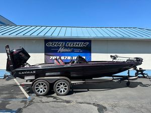 2024 Caymas XS 20 boat on trailer, parked outside a building under clear blue sky.