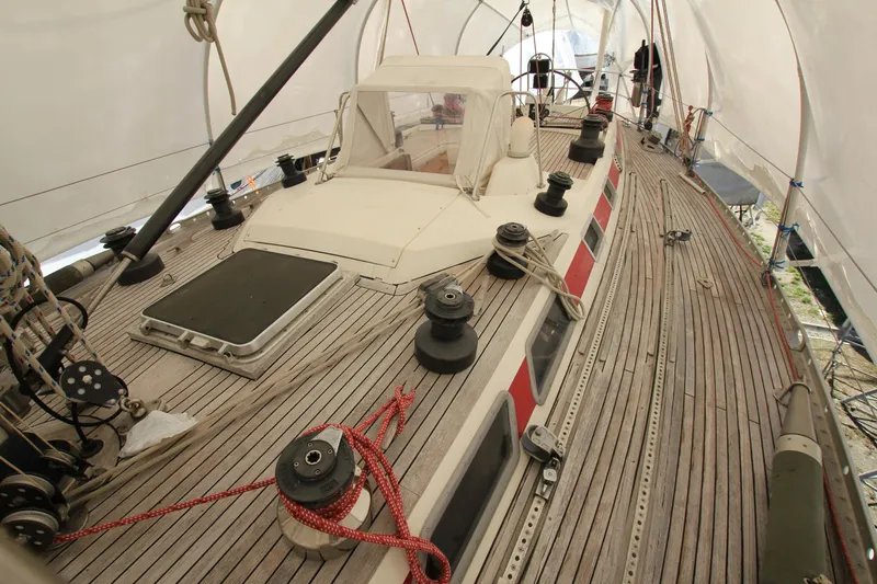 Le Reve Yacht Photos Pics 1983 Nautor Swan 46mkI sailboat deck under protective cover, showcasing winches and teak finish.