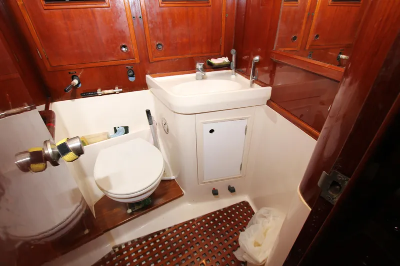 Le Reve Yacht Photos Pics Bathroom interior of 1983 Nautor Swan 46mkI yacht with wooden cabinetry and compact fixtures.