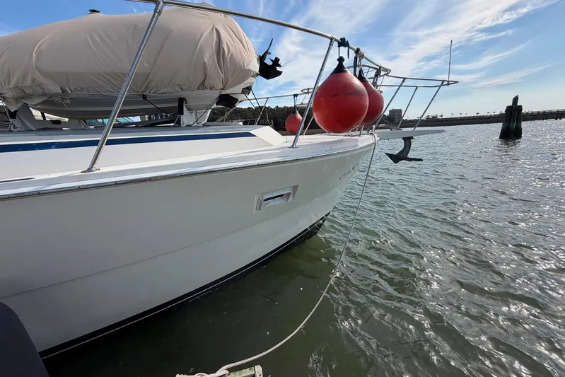 Frayed Knot Yacht Photos Pics 1987 Viking 44 Motor Yacht with red buoys docked on calm water.