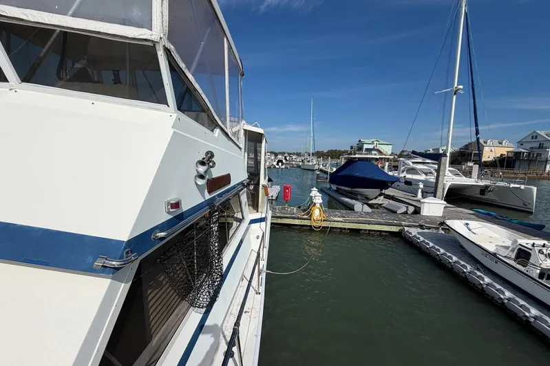 Frayed Knot Yacht Photos Pics 1987 Viking 44 Motor Yacht docked at a marina with other boats under a clear blue sky.