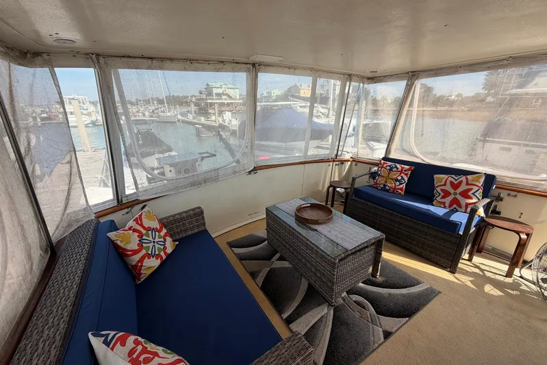 Frayed Knot Yacht Photos Pics Enclosed deck of 1987 Viking 44 Motor Yacht with blue seating and colorful pillows.