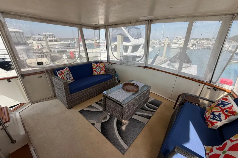 Frayed Knot Yacht Photos Pics Enclosed deck of 1987 Viking 44 Motor Yacht with wicker seating and marina view.