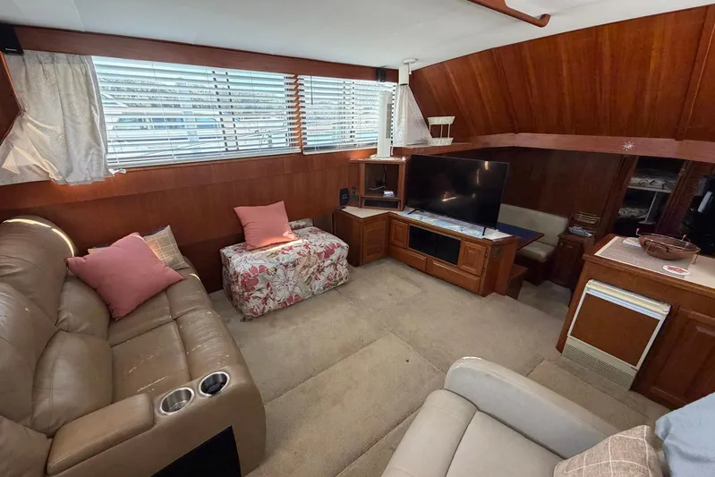 Frayed Knot Yacht Photos Pics 1987 Viking 44 Motor Yacht interior with cozy seating, TV, and wood paneling.