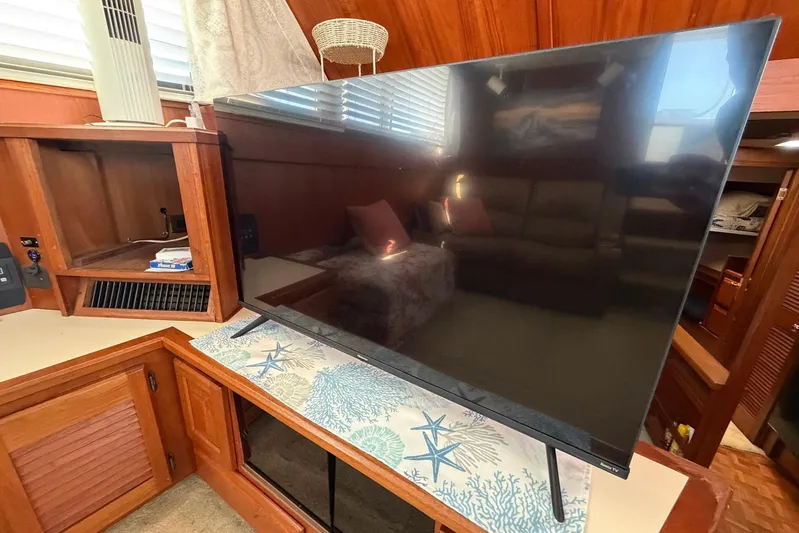 Frayed Knot Yacht Photos Pics Interior of 1987 Viking 44 Motor Yacht with TV and wooden cabinetry.