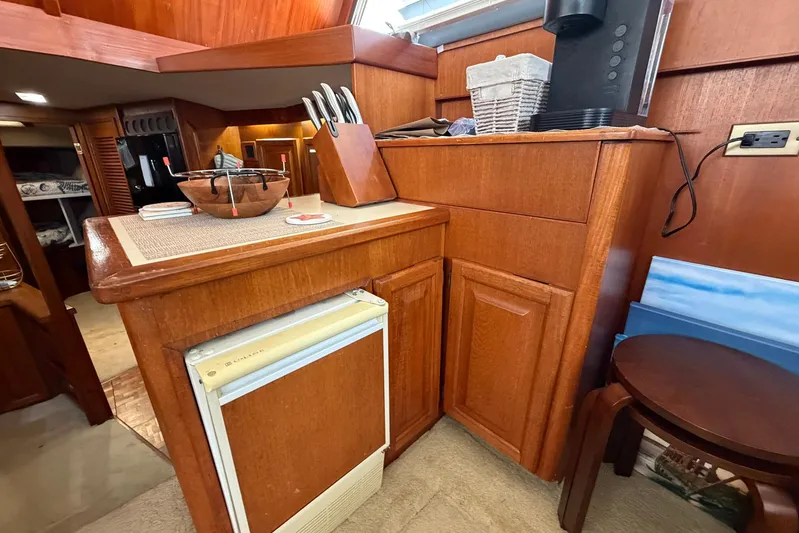 Frayed Knot Yacht Photos Pics 1987 Viking 44 Motor Yacht interior with wooden cabinetry and compact kitchen area.