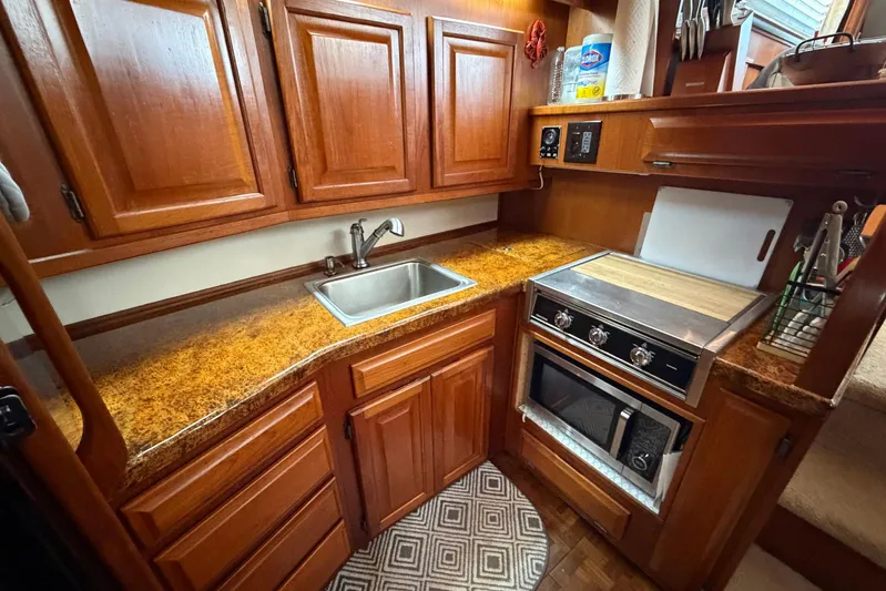 Frayed Knot Yacht Photos Pics 1987 Viking 44 Motor Yacht kitchen with wood cabinets, sink, and stove.