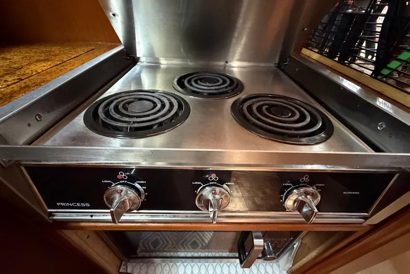 Frayed Knot Yacht Photos Pics Electric stove in 1987 Viking 44 Motor Yacht kitchen, featuring three burners and control knobs.