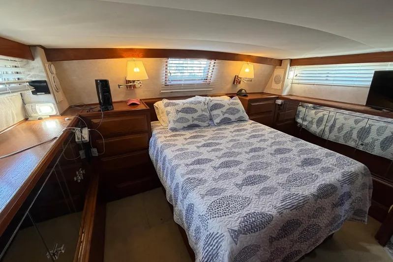Frayed Knot Yacht Photos Pics Cozy bedroom in 1987 Viking 44 Motor Yacht with patterned bedding and wooden accents.