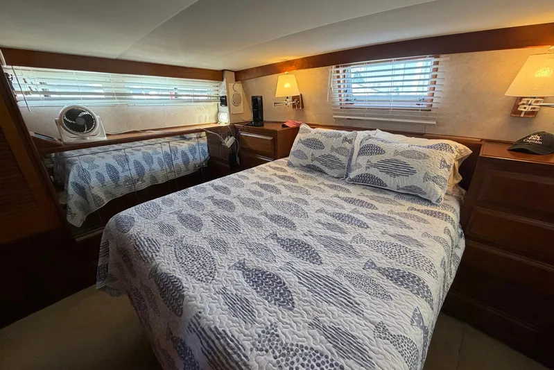 Frayed Knot Yacht Photos Pics Cozy bedroom in 1987 Viking 44 Motor Yacht with nautical-themed bedding and warm lighting.