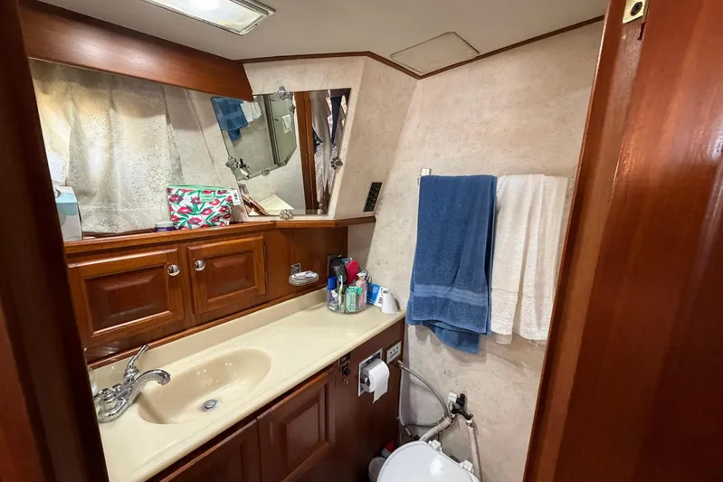 Frayed Knot Yacht Photos Pics Bathroom interior of 1987 Viking 44 Motor Yacht with sink, mirror, and towels.