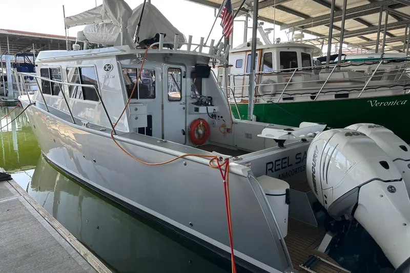 Reel Salty Yacht Photos Pics 2020 Coastal Craft 33 ProFish boat docked in marina, featuring sleek design and powerful outboard motor.