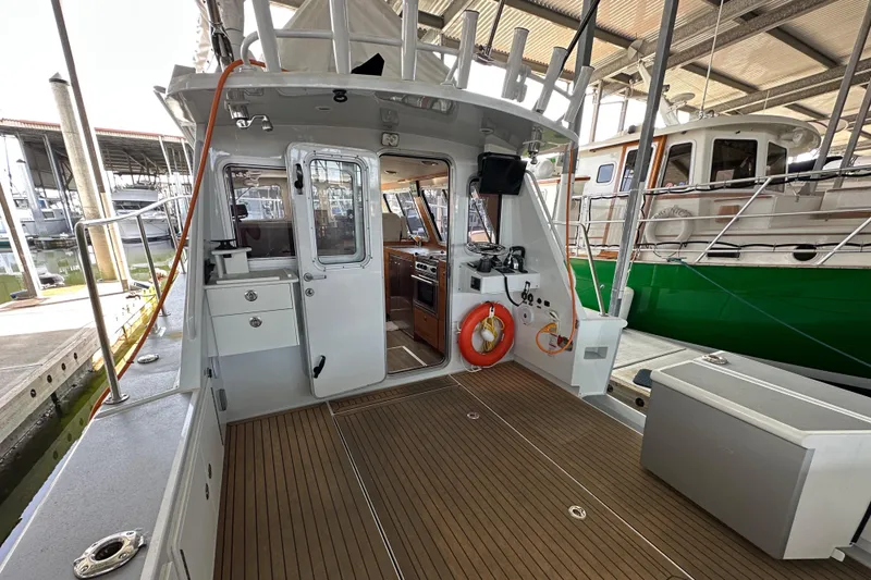 Reel Salty Yacht Photos Pics 2020 Coastal Craft 33 ProFish boat interior with wood deck and fishing equipment.