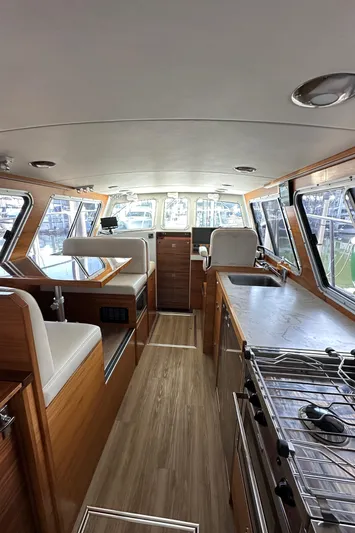 Reel Salty Yacht Photos Pics 2020 Coastal Craft 33 ProFish interior with wood finish, seating, and kitchen area.