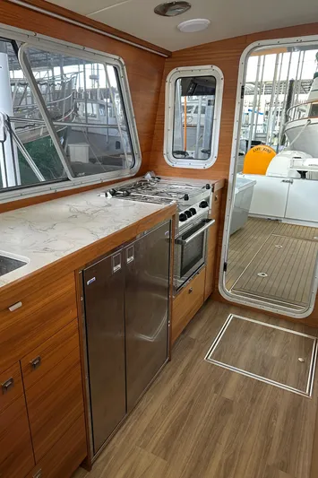 Reel Salty Yacht Photos Pics Interior of 2020 Coastal Craft 33 ProFish with modern kitchen and wood finish.