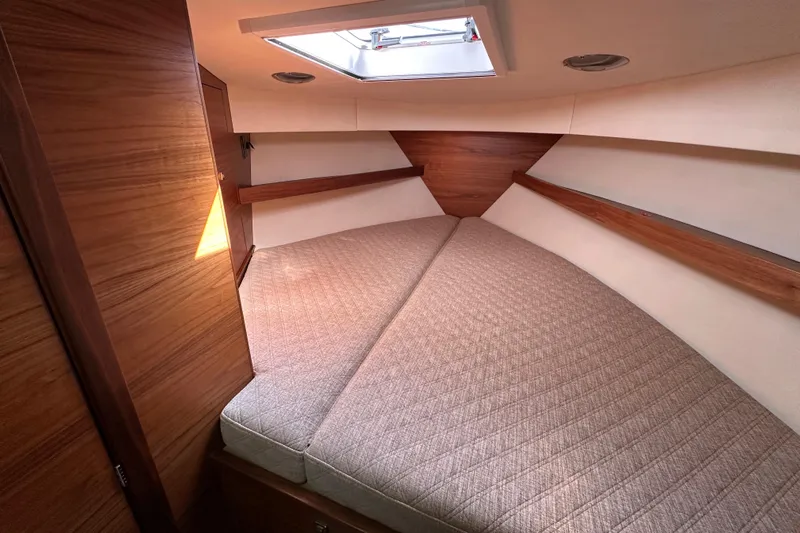 Reel Salty Yacht Photos Pics 2020 Coastal Craft 33 ProFish cabin interior with cozy bed and wooden accents.