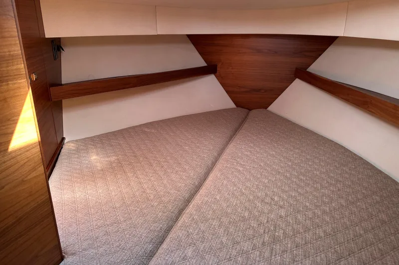 Reel Salty Yacht Photos Pics 2020 Coastal Craft 33 ProFish cabin interior with wood accents and beige bedding.