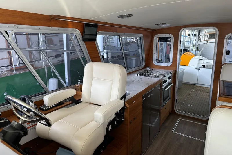 Reel Salty Yacht Photos Pics Interior of 2020 Coastal Craft 33 ProFish boat with helm, kitchen, and seating area.