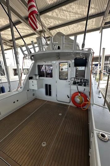 Reel Salty Yacht Photos Pics 2020 Coastal Craft 33 ProFish boat with spacious deck, docked under a metal canopy.