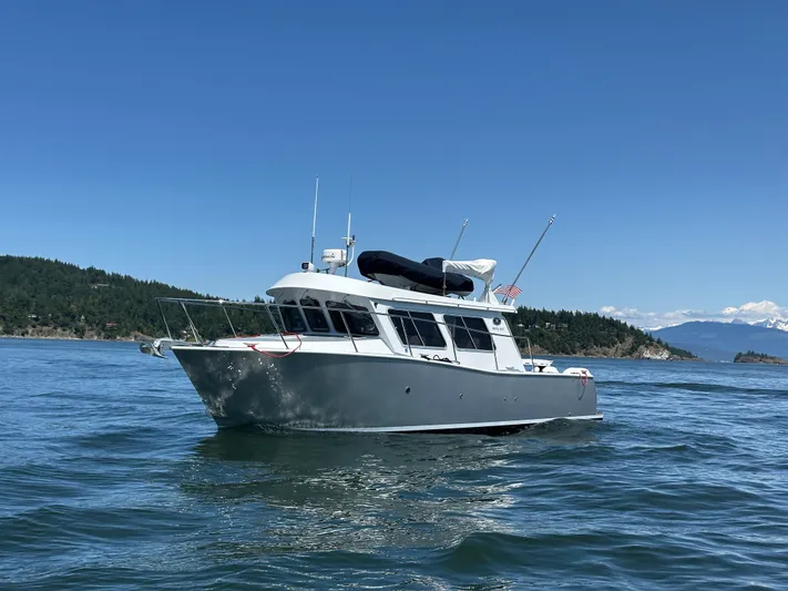 Reel Salty Yacht Photos Pics 2020 Coastal Craft 33 ProFish boat on calm waters with scenic background.