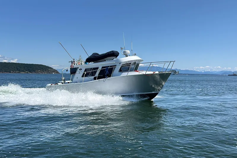 Reel Salty Yacht Photos Pics 2020 Coastal Craft 33 ProFish cruising on open water under clear blue skies.