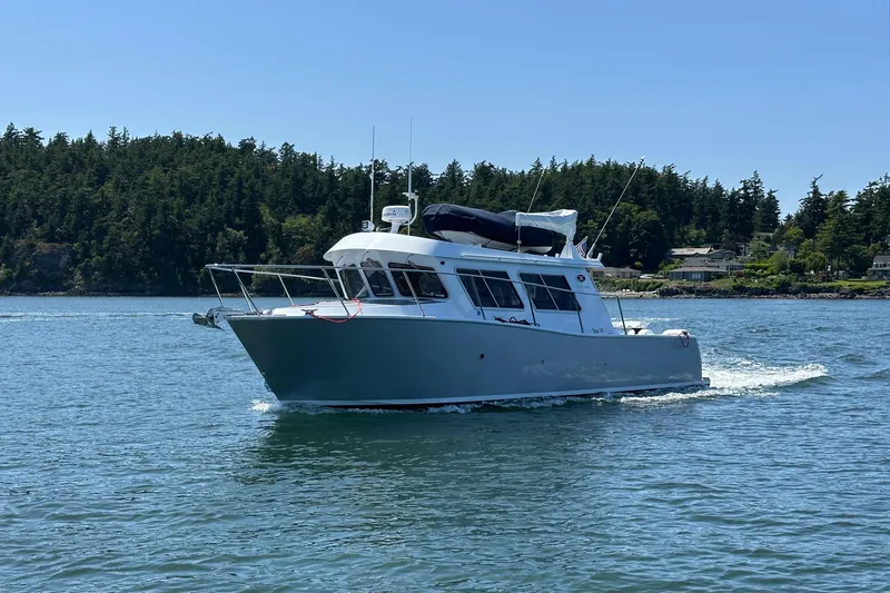 Reel Salty Yacht Photos Pics 2020 Coastal Craft 33 ProFish boat cruising on a serene lake with forested shoreline.