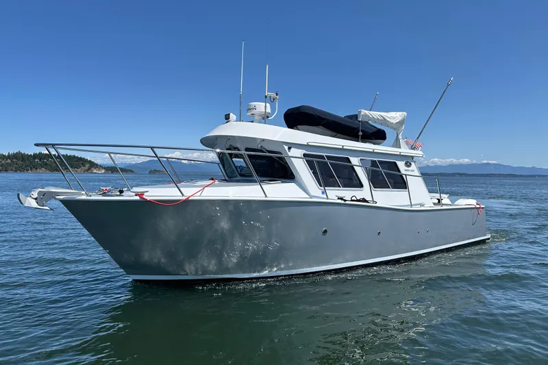 Reel Salty Yacht Photos Pics 2020 Coastal Craft 33 ProFish boat on calm water under clear blue sky.