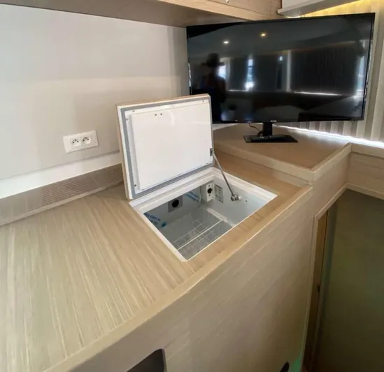  Yacht Photos Pics Interior of 2024 Lagoon 42 yacht with open storage compartment and mounted TV.