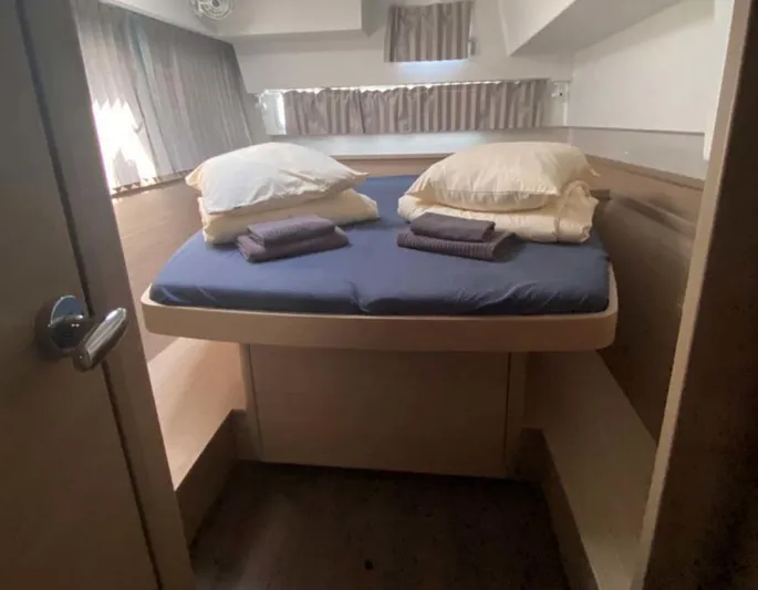  Yacht Photos Pics 2024 Lagoon 42 cabin interior with cozy bed, pillows, and towels.