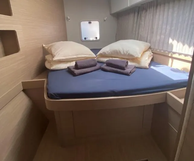  Yacht Photos Pics 2024 Lagoon 42 yacht cabin with neatly arranged bed and towels.