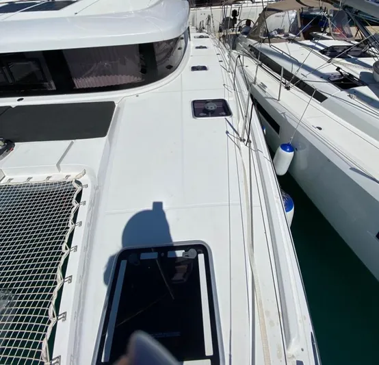  Yacht Photos Pics 2024 Lagoon 42 catamaran deck view with netting and hatches.
