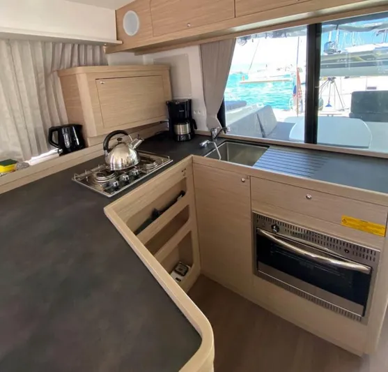  Yacht Photos Pics Modern kitchen interior of 2024 Lagoon 42 yacht with stove, sink, and appliances.