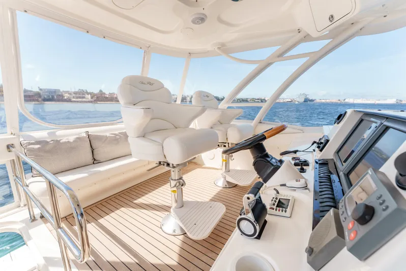  Yacht Photos Pics 2005 Sea Ray 550 Sedan Bridge yacht interior with helm, white seats, and navigation equipment.