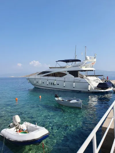 Tais Octavia Yacht Photos Pics Luxury 2005 Sunseeker 75 yacht docked in clear blue waters.