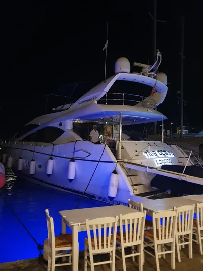 Tais Octavia Yacht Photos Pics Luxury Sunseeker 75 yacht, 2005 model, docked at night with blue underwater lights.