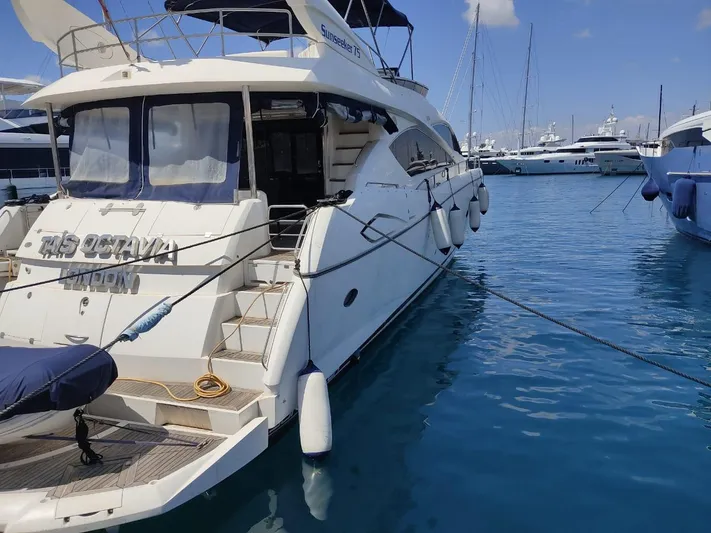 Tais Octavia Yacht Photos Pics 2005 Sunseeker 75 yacht docked in a marina, surrounded by clear blue water.