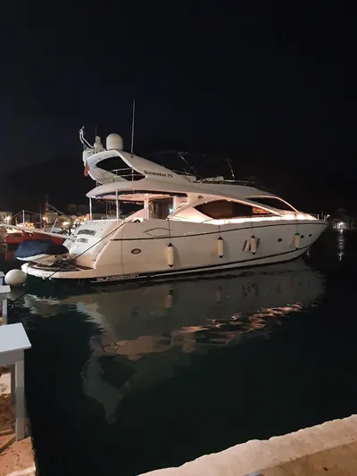 Tais Octavia Yacht Photos Pics Luxury 2005 Sunseeker 75 yacht docked at night, illuminated and reflecting on water.